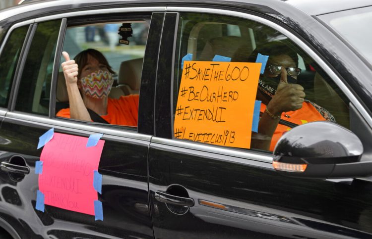 Varias personas participan en una caravana el miércoles 22 de julio de 2020 frente a la oficina del senador John Kennedy en el edificio federal Hale Boggs, en Nueva Orleáns, Luisiana, para solicitar se amplíen los pagos de la ayuda de 600 dólares semanales a quienes perdieron sus empleos por el coronavirus. Foto: Max Becherer/The Advocate vía AP.