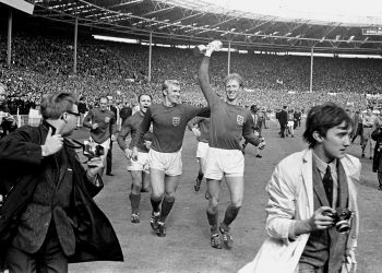 El 30 de julio de 1966 el inglés Jack Charlton sostiene la copa Jules Rimet mientras saluda al público en Wembley acompañado de su compañero Bobby Moore luego de derrotar 4-2 a Alemania Occidental. Foto: PA via AP.