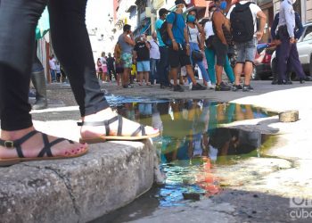 Compradores y policías en la cola en las afueras de la tienda de Prado 20, en La Habana, una de las nuevas tiendas que iniciaron la venta de artículos en Moneda Libremente (MLC) este lunes 20 de julio de 2020. Foto: Otmaro Rodríguez.