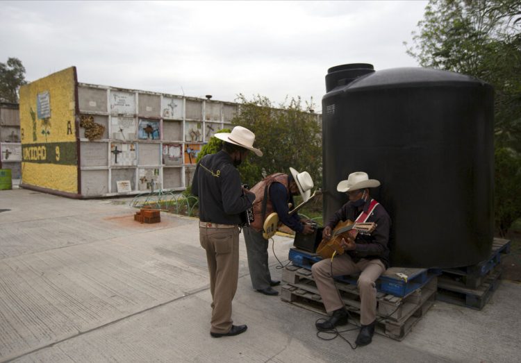 Un trío de músicos con mascarillas para protegerse del coronavirus espera clientes el jueves 9 de julio de 2020 en el cementerio municipal de Nezahualcóyotl, cerca del DF. Foto: Fernando Llano/AP.