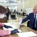 El presidente ruso Vladimir Putin muestra su pasaporte a una trabajadora electoral poco antes de votar el miércoles 1 de julio de 2020, en Moscú. Foto: Alexei Druzhinin/Sputnik vía AP.