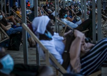 Personas con barbijos asisten a la proyección de una película al aire libre, en Paris. Las playas artificiales temporales funcionarán hasta el 31 de agosto de 2020. Foto: MOHAMMED BADRA/ EFE / EPA.