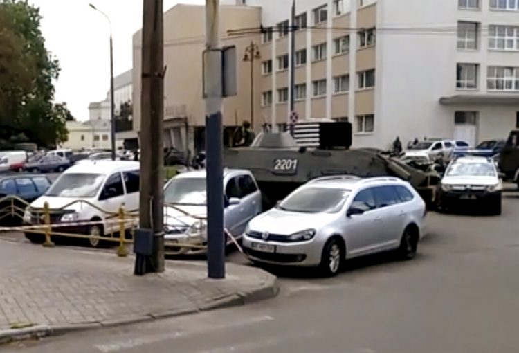 Una calle cortada por un vehículo blindado y un auto policial, a la derecha, después de que un hombre armado tomara como rehenes a unas 20 personas en la ciudad ucraniana de Lutsk, unos 400 kilómetros al oeste de Kiev, el martes 21 de julio de 2020. Foto: AP.