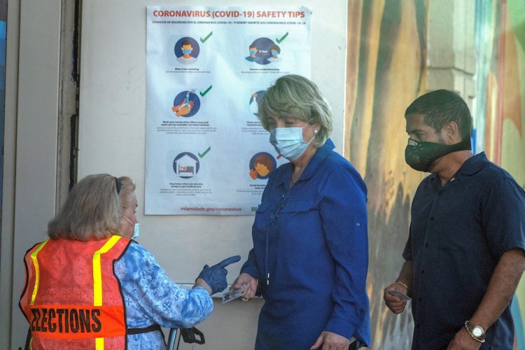 En día de elecciones primarias locales, dos electores se identifican en el centro de votación protegidos contra la pandemia. | Cristóbal Herrera / EFE