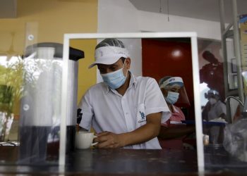 Trabajadores con mascarilla en un restaurante de El Salvador. Foto: Rodrigo Sura / EFE.