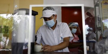 Trabajadores con mascarilla en un restaurante de El Salvador. Foto: Rodrigo Sura / EFE.