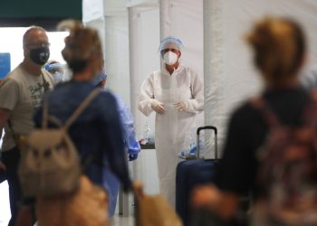 Personal médico espera para revisar a pasajeros en el aeropuerto Malpensa de Milán, el jueves 20 de agosto de 2020. (AP Foto/Antonio Calanni)