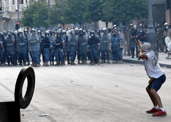 Un manifestante lanza piedras la policía antidisturbios libanesa con una honda durante una protesta en una de las carreteras que conducen al parlamento en Beirut, Líbano, el 10 de agosto de 2020. Gobierno libanés dimitió en medio de continuas protestas por la explosión del puerto de Beirut. Foto: WAEL HAMZEH/EFE/EPA.