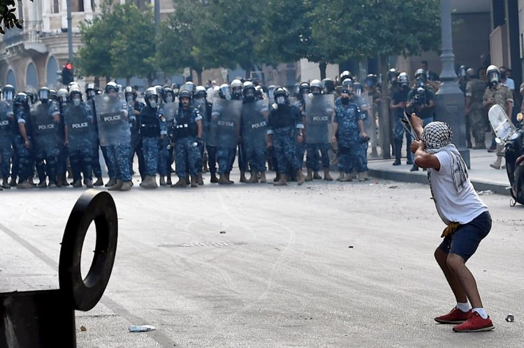 Un manifestante lanza piedras la policía antidisturbios libanesa con una honda durante una protesta en una de las carreteras que conducen al parlamento en Beirut, Líbano, el 10 de agosto de 2020. Gobierno libanés dimitió en medio de continuas protestas por la explosión del puerto de Beirut. Foto: WAEL HAMZEH/EFE/EPA.