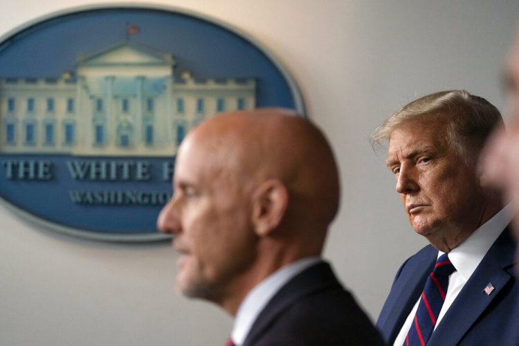 El presidente Donald Trump escucha mientras el comisionado de la Administración de Alimentos y Medicamentos, Stephen Hahn, habla durante una rueda de prensa en la Casa Blanca, en Washington, el domingo 23 de agosto de 2020.  Foto: Alex Brandon/AP.