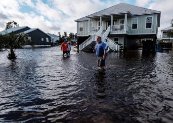 Una familia intenta cruzar una calle en Orange Beach, Alabama, inundada por el huracán Sally. Foto: Dan Anderson / EFE.