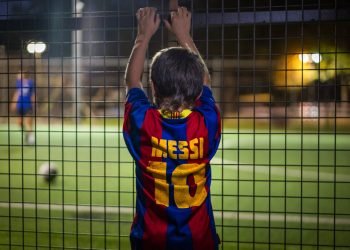 Un niño con una camiseta de Lionel Messi observa un partido de fútbol en Banyoles, España. Foto: Emilio Morenatti/AP/archivo.