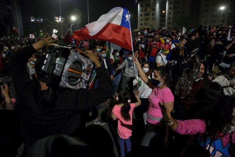 Decenas de personas celebran luego de conocer resultados parciales del plebiscito constitucional, que apuntaban al triunfo por una nueva Carta Magna, en Santiago de Chile, el domingo 25 de octubre de 2020. Finalmente, se impuso la opción de reemplazar la actual Carta Magna, heredada de la dictadura de Augusto Pinochet. Foto: Alberto Valdés / EFE.