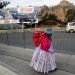 Una mujer camina cerca de una valla con propaganda electoral en El Alto, Bolivia, el sábado 17 de octubre de 2020. Foto: Juan Karita/AP.