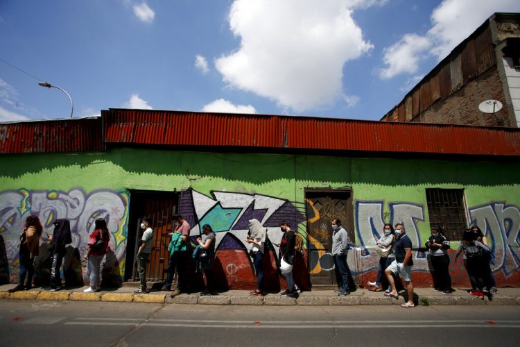 Personas esperan su turno para votar durante el referéndum para decidir si el país debe reemplazar su Constitución de 40 años, redactada durante la última dictadura, en Santiago de Chile, el domingo 25 de octubre de 2020.  Foto: Luis Hidalgo/AP.