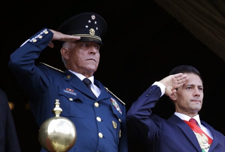 En esta fotografía del 16 de septiembre de 2016, el secretario mexicano de Defensa, general Salvador Cienfuegos, y el presidente Enrique Peña Nieto saludan durante el desfile por el Día de la Independencia en la plaza principal de la Ciudad de México. Foto: Rebecca Blackwell/AP.