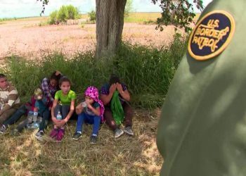 Un agente de ICE custodia a tres niños en la frontera. Foto: UN-ONU.