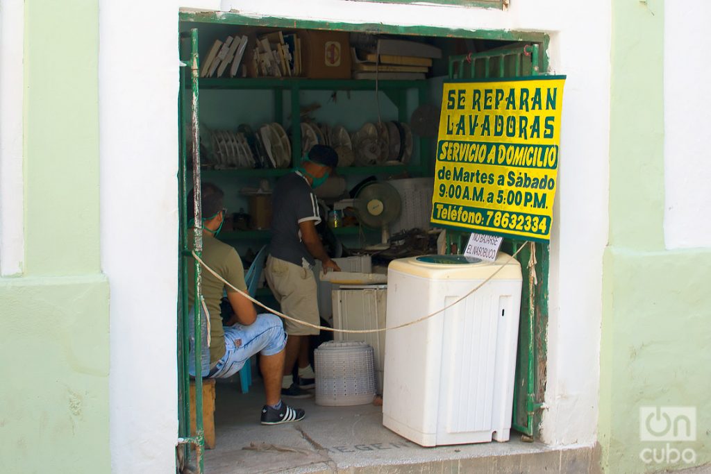 Trabajadores en un taller privado de reparaciones de lavadoras, tras la flexibilización de las restricciones por la COVID-19 en La Habana. Foto: Otmaro Rodríguez.
