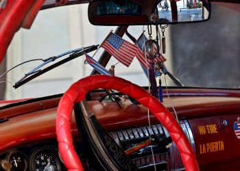Vista del interior de un automóvil clásico de fabricación norteamericana, adornado con banderas de Cuba y Estados Unidos en La Habana. Foto: Ernesto Mastrascusa / EFE/Archivo.