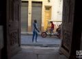 Unas personas pasan frente a unas puertas exteriores en La Habana. Foto: Otmaro Rodríguez.