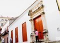 Unas personas pasa frente a unas puertas exteriores en La Habana. Foto: Otmaro Rodríguez.