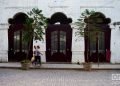 Unas personas pasan frente a unas puertas exteriores en La Habana. Foto: Otmaro Rodríguez.