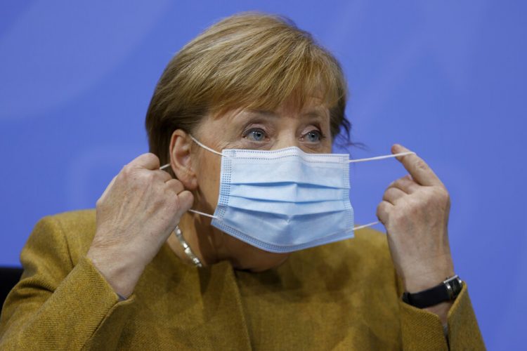 La canciller alemana Angela Merkel se retira la mascarilla el miércoles 25 de noviembre de 2020 antes de una conferencia de prensa. Foto: Odd Andersen/Pool Foto vía AP.