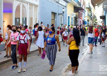 Personas con mascarillas en la calle Obispo de La Habana, entre ellas estudiantes de la enseñanza primaria, tras el reinicio del curso escolar en la capital cubana. Foto: Otmaro Rodríguez.