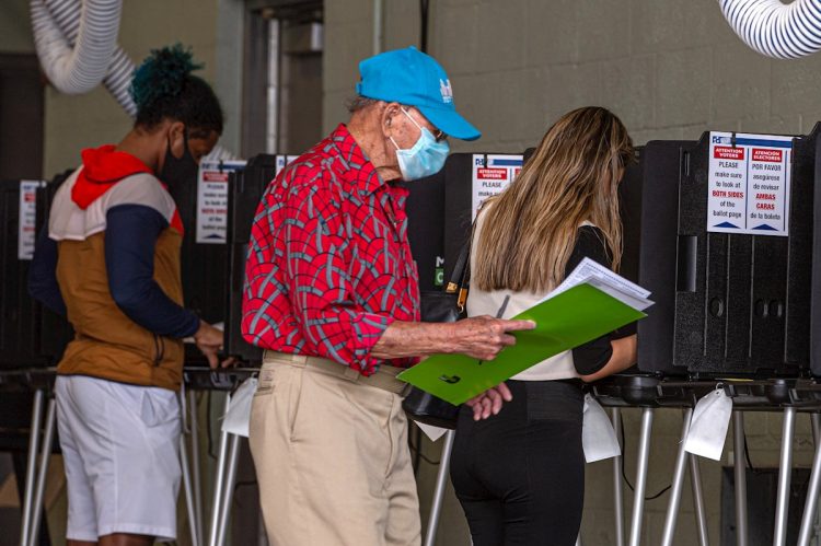Personas llenan sus papeletas de votación en el centro de votación en Miami Beach, Florida, el martes 3 de noviembre de 2020. Foto: Giorgio Viera / EFE.