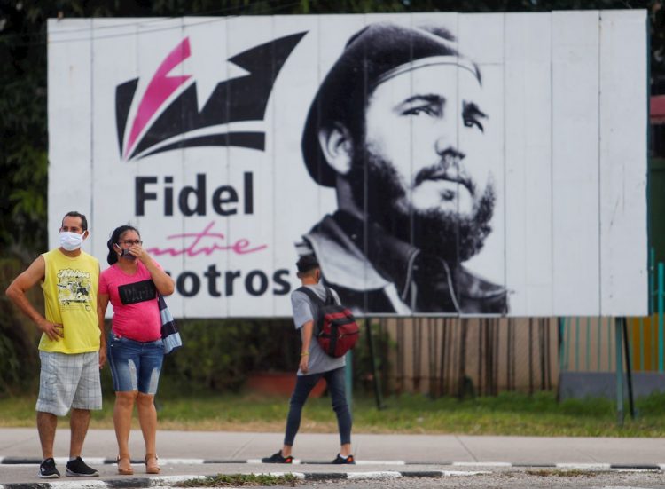 Algunos transeúntes caminan frente a una valla con la imagen de Fidel Castro en La Habana, el 25 de noviembre de 2020, día en que se conmemora el cuarto aniversario de la muerte del líder cubano. Foto: Yander Zamora / EFE.