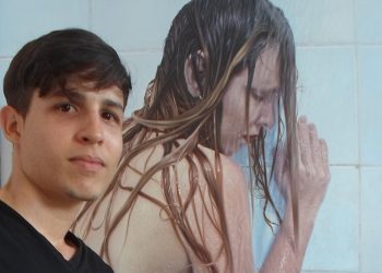 El joven artista cubano Yoandry Cáceres Rivero junto a su obra "Violencia No", premiada en España. Foto: Perfil de Facebook del artista.