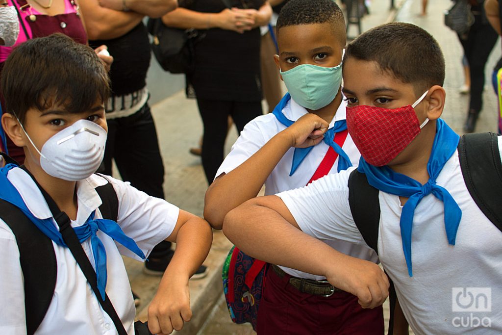 Tres niños se saludan antes de entrar a su escuela en La Habana, durante la pandemia de la COVID-19. Foto: Otmaro Rodríguez / Archivo.