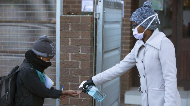 Un alumno recibe desinfectante en una escuela de Johannesburgo. Foto: Denis Farrell/AP.