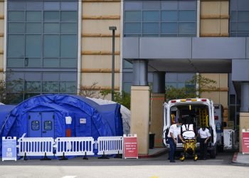 Trabajadores médicos retirando una camilla de una ambulancia cerca de carpas médicas erigidas afuera de la sala de emergencias del UCI Medical Center en Irvine, California.  Foto: Ashley Landis/ Archivo/AP.