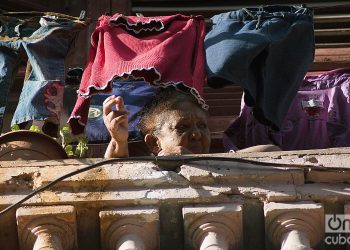 Una anciana se asoma al balcón durante el rebrote de la COVID-19 en La Habana, en enero de 2021. Foto: Otmaro Rodríguez.