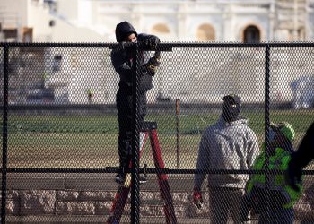 Trabajadores refuerzan la seguridad alrededor del Capitolio, al día siguiente del asalto por parte de seguidores de Donald Trump. Foto: Michael Reynolds / EFE.