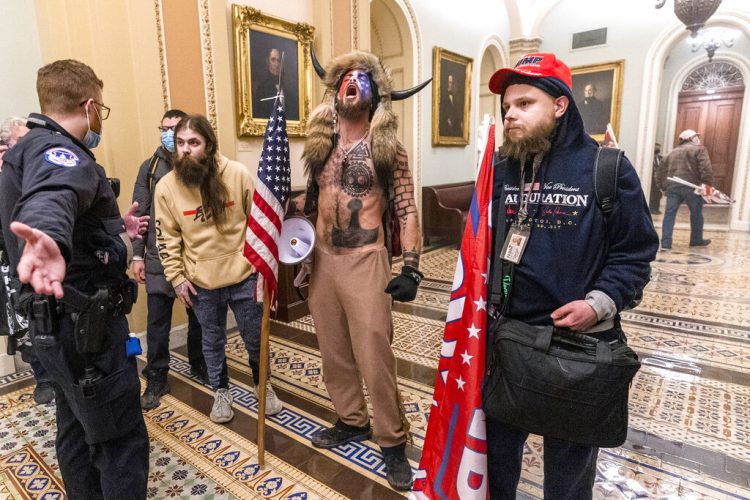 Partidarios de Donald Trump, incluido Jacob Chansley (con el torso descubierto y un sombrero de piel con cuernos), fotografiados durante la toma del Congreso el 6 de enero del 2021 en Washington. Foto: Manuel Balce Ceneta/AP.
