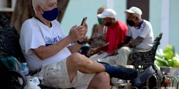 Un hombre revisa internet en su móvil en un parque de La Habana. Foto: Otmaro Rodríguez/Archivo OnCuba.