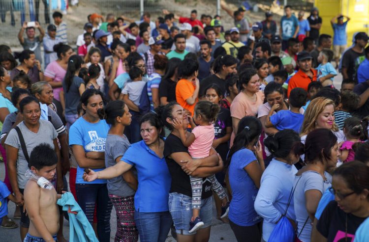 Migrantes, muchos de ellos devueltos a México por la política migratoria del entonces presidente de Estados Unidos Donald Trump, esperan en final para recibir alimentos en un campamento en el puente internacional en Matamoros, México. Foto: Veronica G. Cárdenas/Ap/ archivo.