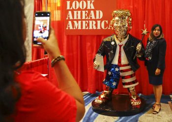 Una mujer se toma una foto junto a una estatua dorada de Donald Trump en la Conferencia Conservadora de Acción Política el 26 de febrero de 2021 en Orlando, Florida. Foto: Sam Thomas/AP.