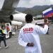 Un trabajador de la salud sostiene una bandera nacional rusa mientras es descargado un cargamento de la vacuna rusa Sputnik V contra el COVID-19, en el Aeropuerto Internacional Simón Bolívar en Maiquetía, Venezuela, el sábado 13 de febrero de 2021  Foto: Matías Delacroix/Ap.