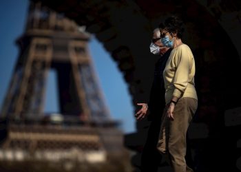 Dos personas caminan cerca de la Torre Eiffel, en París, Francia. Foto: Ian Langsdon / EFE.