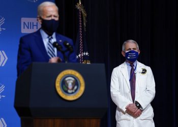 El presidente Joe Biden hace declaraciones el jueves 11 de febrero de 2021 durante una visita al Laboratorio de Patogénesis Viral, en los Institutos Nacionales de Salud, en Bethesda, Maryland. Al fondo está el doctor Anthony Fauci, director del Instituto Nacional de Alergias y Enfermedades Infecciosas. (AP Foto/Evan Vucci)