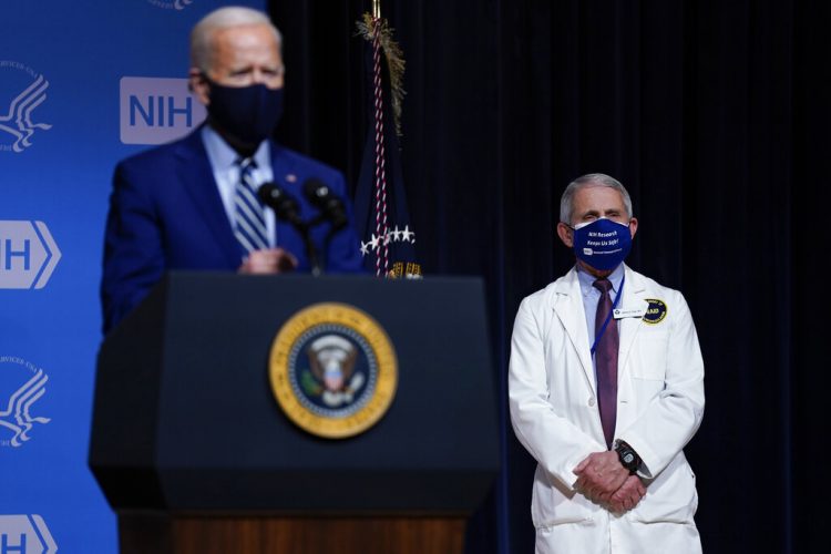 El presidente Joe Biden hace declaraciones el jueves 11 de febrero de 2021 durante una visita al Laboratorio de Patogénesis Viral, en los Institutos Nacionales de Salud, en Bethesda, Maryland. Al fondo está el doctor Anthony Fauci, director del Instituto Nacional de Alergias y Enfermedades Infecciosas. (AP Foto/Evan Vucci)