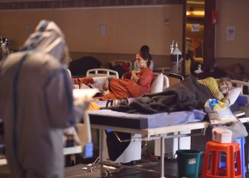 Un médico indio que usa equipo de protección personal examina a los pacientes dentro de un centro de atención a enfermos con la COVID 19 y una sala de aislamiento cerca de un hospital en Nueva Delhi, la India, el 27 de abril de 2021. Foto: Idrees Mohammed / EFE.