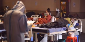 Un médico indio que usa equipo de protección personal examina a los pacientes dentro de un centro de atención a enfermos con la COVID 19 y una sala de aislamiento cerca de un hospital en Nueva Delhi, la India, el 27 de abril de 2021. Foto: Idrees Mohammed / EFE.