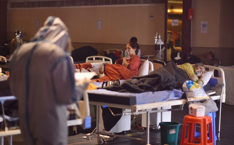 Un médico indio que usa equipo de protección personal examina a los pacientes dentro de un centro de atención a enfermos con la COVID 19 y una sala de aislamiento cerca de un hospital en Nueva Delhi, la India, el 27 de abril de 2021. Foto: Idrees Mohammed / EFE.