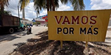 Vista de un cartel que incentiva a los cubanos a producir más azúcar, cerca a la entrada del Central Azucarero Boris Luis Santa Coloma, que permanece en paro de su producción. Foto: EFE/Ernesto Mastrascusa/Archivo.