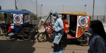 Mototaxis transportan personal de la salud para la vacunación anticovid, en el Cerro El Agustino, en Lima, Perú. Foto: Paolo Aguilar / EFE.