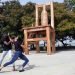 Acto de colocación de una silla gigante de madera, confeccionada por el grupo de artesanos Leo y Migue, en el Paseo de la Alameda de Santiago de Cuba. Foto: Miguel Rubiera / ACN.